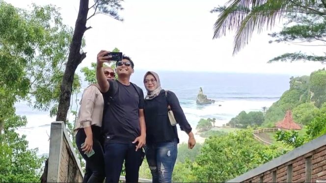
 Wisatawan Berswafoto dengan latar belakang Pantai Buyutan (Foto: Trinoto) 
