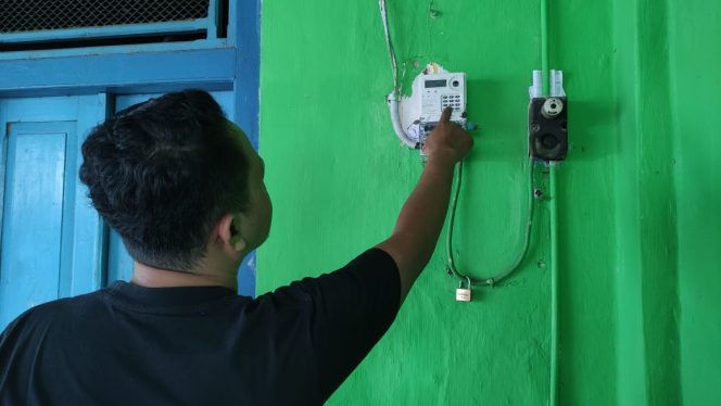 
 Salah Seorang Pelanggan Memasukkan Token Listrik (foto: Trinoto) 